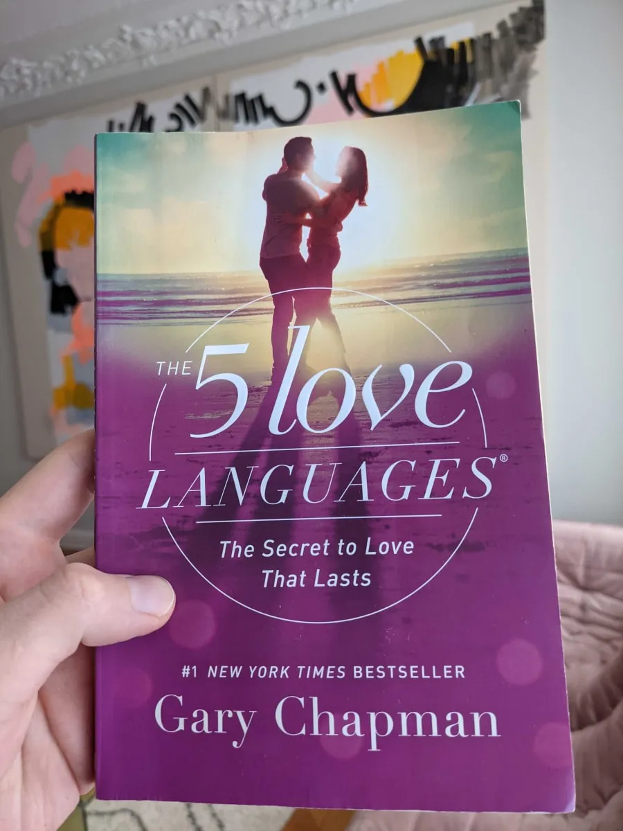 A hand holding the book "The 5 Love Languages" by Gary Chapman