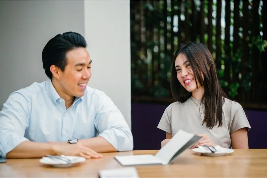 A man and a woman sitting at a table smiling
